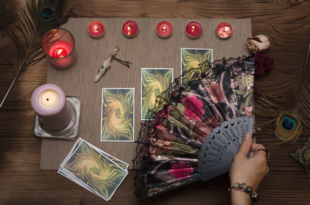 Tarot cards on wooden table of fortune teller. Top view.